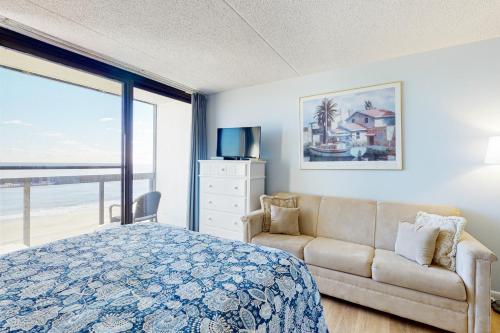 大洋城Golden Sands 809的一间卧室配有一张床、一张沙发和一个窗口