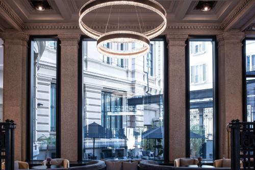 米兰Radisson Collection Hotel, Palazzo Touring Club Milan的大堂设有吊灯和大窗户