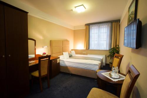 热舒夫阿蒙吧萨多斯基热舒夫酒店的配有一张床和一张书桌的酒店客房
