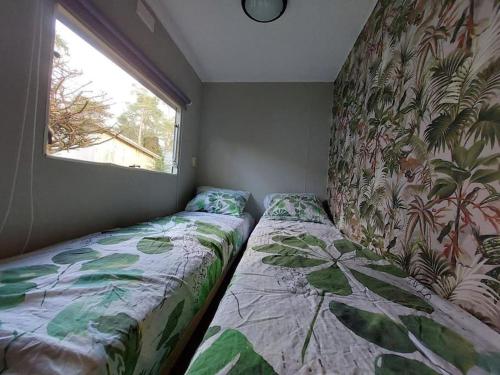 洪德洛Te Huur: leuke 4-persoons Stacaravan op top locatie!的一间卧室设有两张靠窗的床。
