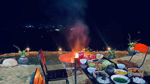 Làng CacDu Gia Panorama的火旁一张桌子,上面有食物