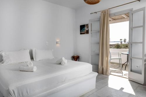 布拉卡Helios Beach Studios的一间白色的卧室,配有一张床,享有海景