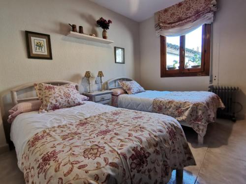 托莱多Casa Alfonso Toledo Más que una casa un hogar的一间卧室设有两张床和窗户。