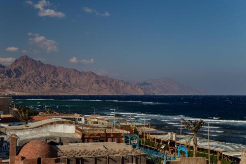 达哈布Al Deira Dahab Hotel的享有大海和山脉的背景景色。