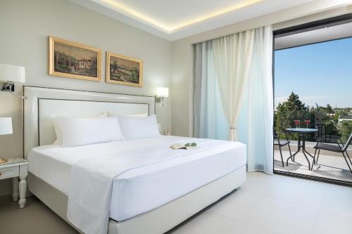 尼亚·卡利克拉提亚Light Blue Hotel的白色卧室设有一张大床和一个阳台