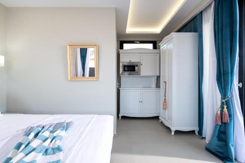 尼亚·卡利克拉提亚Light Blue Hotel的白色的卧室设有床和窗户