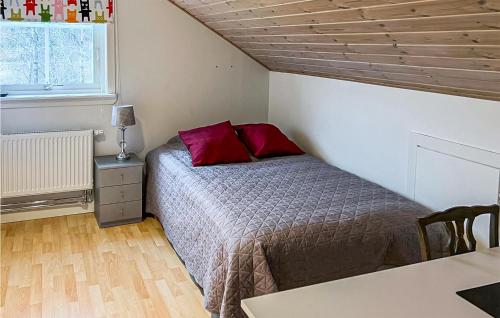 龙讷比Awesome Home In Ronneby With Kitchen的一间卧室配有一张带红色枕头的床