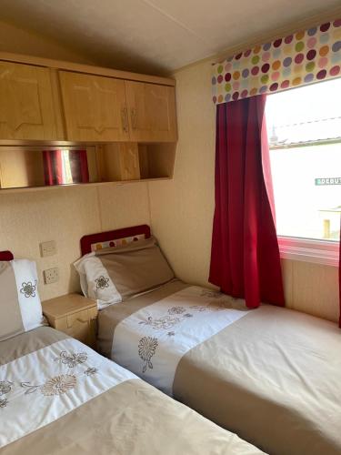 牛顿斯图尔特Immaculate 2-Bed Static Caravan at Monrieth的小房间设有两张床和窗户