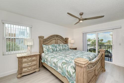 布雷登顿海滩Absolute Anna Maria-Private Beach Access-Heated Pool-Water Views From Every Room的一间卧室配有一张床和吊扇