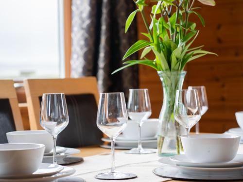 金罗斯Chalet Loch Leven Lodge 10 by Interhome的一张桌子,上面有酒杯和花瓶