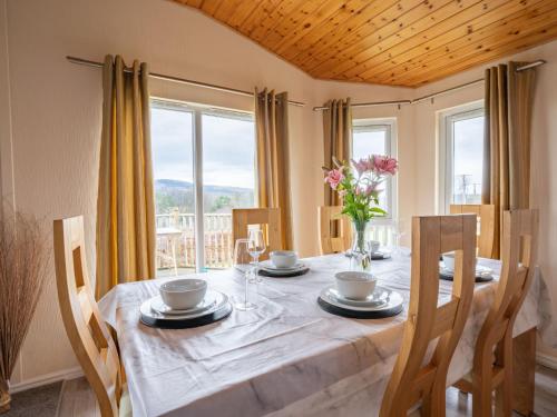 金罗斯Chalet Loch Leven Lodge 4 by Interhome的一间带桌椅和窗户的用餐室
