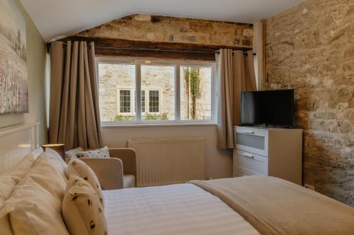 OtheryLittle England Retreats - Cottage, Yurt and Shepherd Huts的一间卧室设有一张床、一个窗口和一台电视