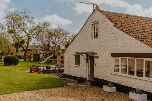 OtheryLittle England Retreats - Cottage, Yurt and Shepherd Huts的小屋的后方设有游乐场