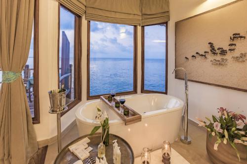 米查维Konokono Beach Resort and Isaraya Luxury Overwater Villas的带浴缸的浴室和大窗户