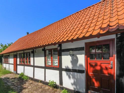 维斯特索马肯Holiday Home Viggo - 300m from the sea in Bornholm by Interhome的一座带橙色屋顶和红色门的小房子