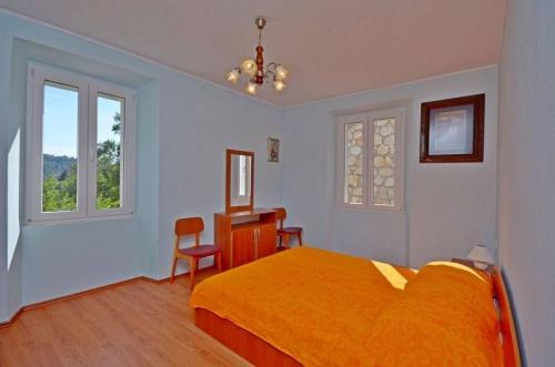 拉斯托伏House Marija的一间卧室配有一张床、一张书桌和两个窗户。
