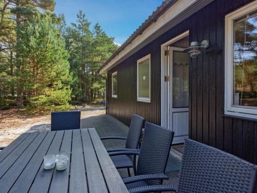 维斯特索马肯Holiday Home Hildegerd - 500m from the sea in Bornholm by Interhome的天井上的木桌和椅子