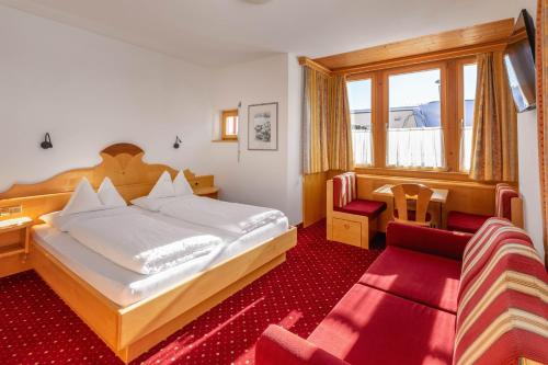 雷西亚Hotel Schwarzer Adler的一间卧室配有一张大床和红地毯