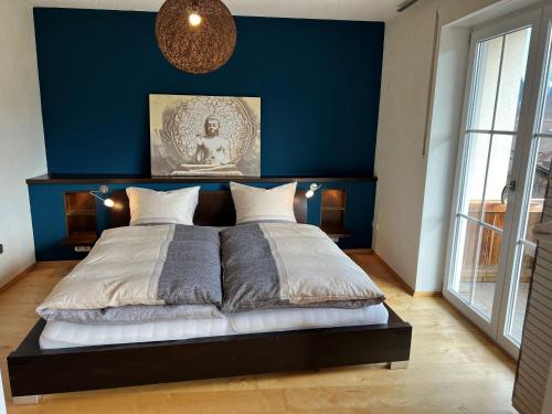 希格斯多夫Chiemgauer Ferienhaus的蓝色墙壁间的一张床位