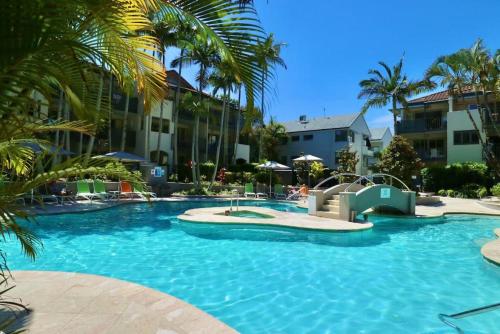 努萨角225 2 Bedroom Garden Oasis French Quarter Resort的度假村内带滑梯的游泳池