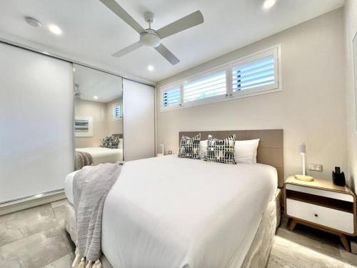 努萨角6Apt Beautifully renovated on Hastings Street的卧室设有一张白色大床和一扇窗户。