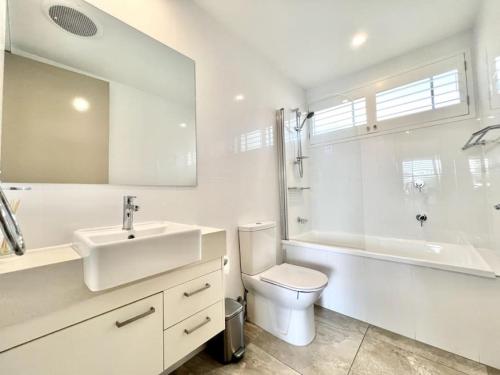 努萨角6Apt Beautifully renovated on Hastings Street的白色的浴室设有水槽、卫生间和浴缸。