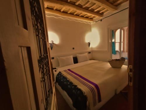 布马伦Riad Bleu Afriqua的一间带床的卧室,位于带窗户的房间内