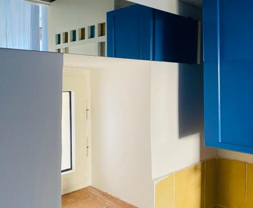 托雷德尔格雷科克拉丽娜乡村民宿的厨房配有蓝色和白色的橱柜和窗户。