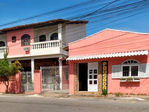 圣佩德罗-达阿尔德亚Pousada Sol de Verão的街道边的粉红色建筑