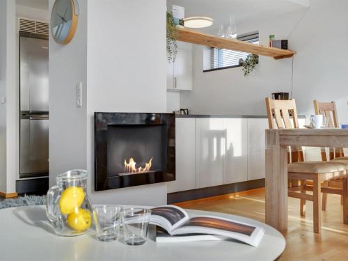 HavnebyApartment Pirkko - 100m from the sea in Western Jutland by Interhome的客厅设有壁炉和带书籍的桌子。
