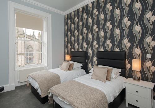 爱丁堡Parliament Sq apt 12 Royal Mile的一间卧室设有两张床,墙上有心形遮盖