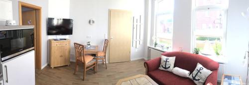 博尔库姆Haus Breslau的客厅配有红色沙发和电视
