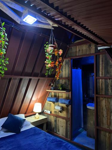 Tinyhouse samaná的卧室配有一张床铺,位于带木墙的房间内