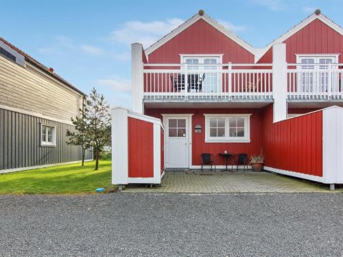 布拉万德Apartment Guthir - 1-2km from the sea in Western Jutland by Interhome的红色的房子,设有白色阳台和红色门