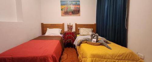 利马Lima Airport Hostel with FREE AIRPORT PICK UP的两张睡床彼此相邻,位于一个房间里