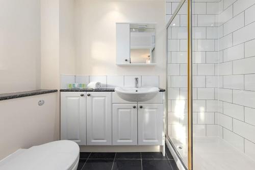 奥平顿Flourish Apartments - Footbury House - Orpington的白色的浴室设有水槽和卫生间。