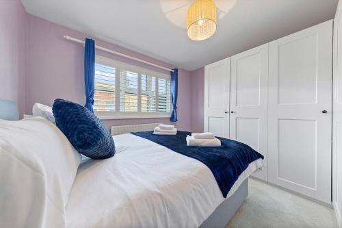 奥平顿Flourish Apartments - Footbury House - Orpington的卧室配有带蓝色枕头的大型白色床