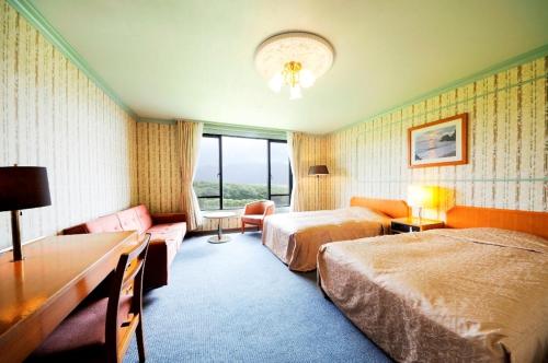 八丈町八丈岛美景酒店的酒店客房,设有两张床和一张沙发