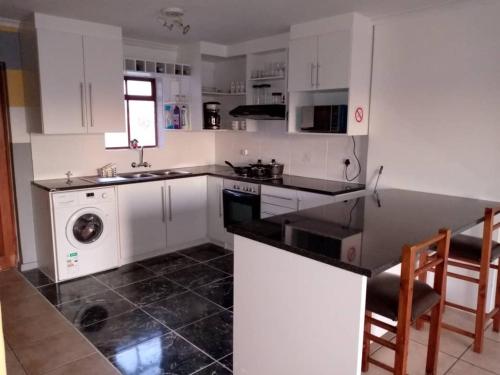 开普敦Gabby's apartment的厨房配有白色橱柜、水槽和洗碗机。