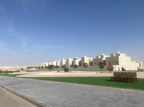 利雅德Riyadh Salman Villa فيلا的一座公园,在一座建筑前有两把长椅