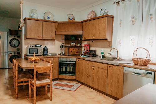 Casa Capricho del Destino的厨房配有木制橱柜、木桌和桌子。