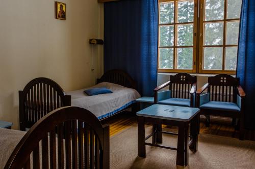 尤斯瓦拉莫瓦拉蒙罗斯塔利酒店的一间卧室配有两把椅子、一张床和窗户