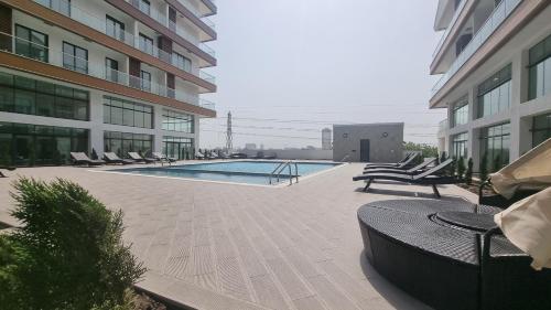 BawaleshiThe Signature Luxury suites CPG的一座带躺椅的建筑内的游泳池