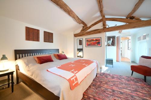 La Mothe-Saint-HérayMas des Gourmands的一间卧室配有一张大床和一张红色椅子