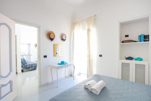 阿纳卡普里La Meraviglia Guest House的卧室拥有白色的墙壁,配有带毛巾的床。