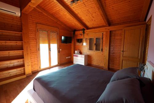 代尔特布雷Casa la Pau的木制客房内的一间卧室配有一张大床