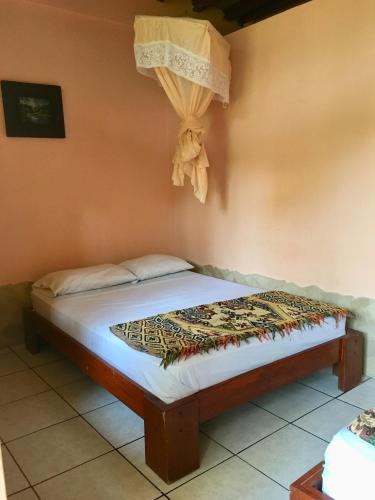 洛佩斯港Hostal Machalilla的墙上挂帘的房间里一张床位