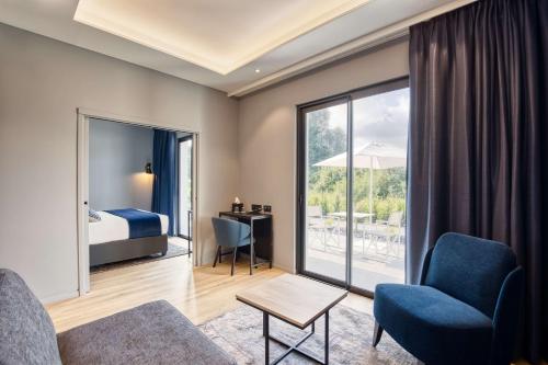 昂泽圣奥宾Best Western Plus Le Fairway Hotel & Spa Golf d'Arras的酒店客房配有床、沙发和椅子