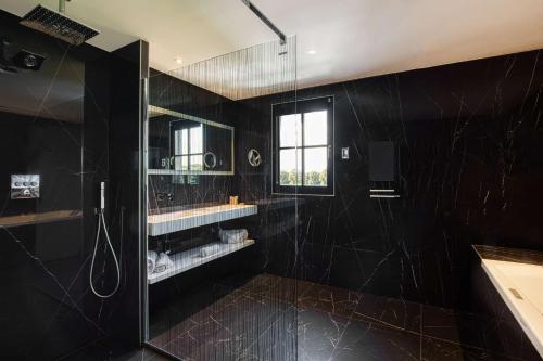 昂泽圣奥宾Best Western Plus Le Fairway Hotel & Spa Golf d'Arras的带淋浴的黑色浴室和窗户。