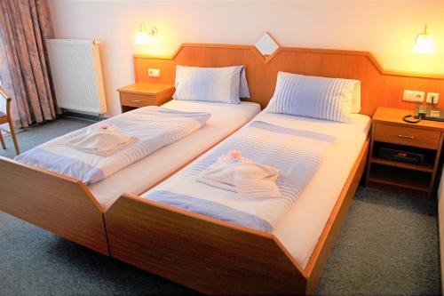 伦韦格地区诺伊豪斯Waldhotel Feldbachtal的两张位于酒店客房的床,配有毛巾